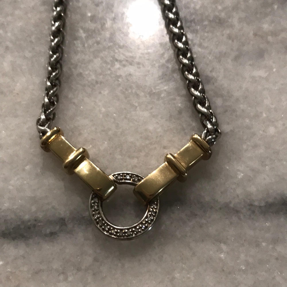 Silver and gold necklace. Chain is braided and it fits close the neck.